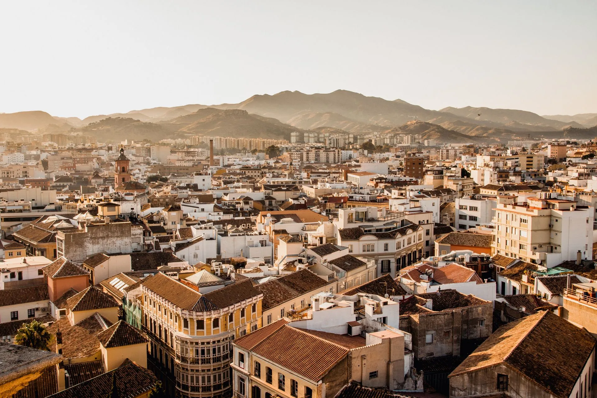 Málaga old-town rooftops and mountains at golden hour